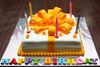 White+birthday+cake+with+large+orange+ribbon+and+Happy+Birthday+letters+in+various+colors.JPG